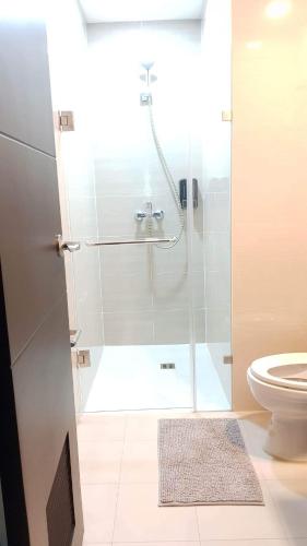 een badkamer met een douche en een toilet bij 101 Newport blvd C2 4F by Rechelle Nunag in Manilla