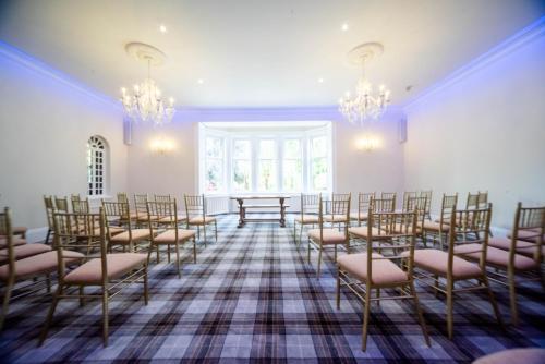 an empty room with chairs and tables and chandeliers at Tinto Hotel in Symington