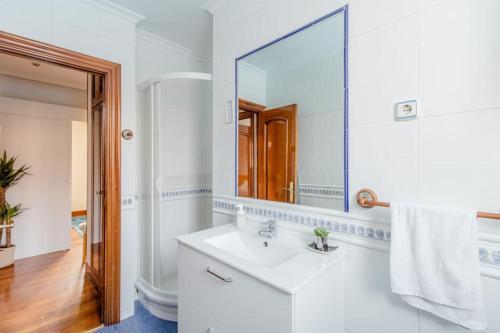 a white bathroom with a sink and a mirror at Bilbao-Barakaldo cerca del BEC 5’/ A 15’ de Bilbao in Barakaldo