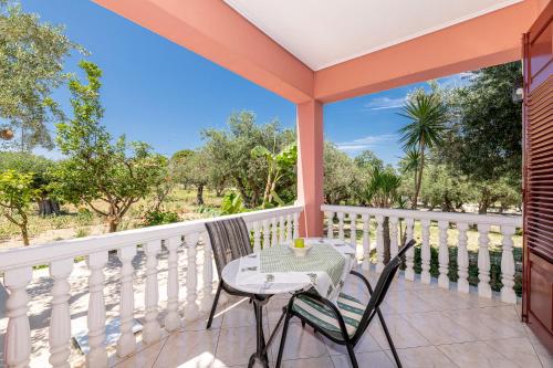 a patio with a table and chairs on a balcony at Arazzo Apartments in Vasilikos