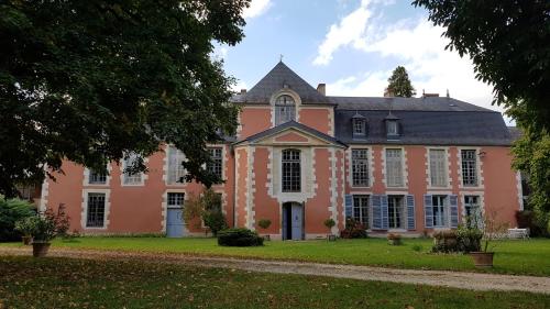 un grand bâtiment rose avec un toit noir dans l'établissement Le nid de Dany, à Cosne Cours sur Loire