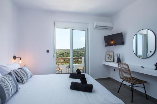 a white bedroom with a large bed and a mirror at Villa Tranquila Rhodes in Psinthos