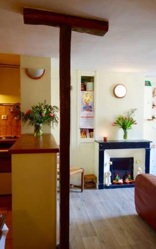 - un salon avec une cheminée et un poteau en bois dans l'établissement Appartement Quartier Latin 4 personnes, à Paris