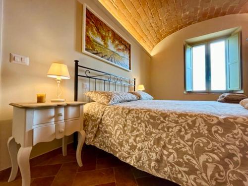 a bedroom with a bed and a table with a lamp at Sangi Chianti Vacations in Poggibonsi