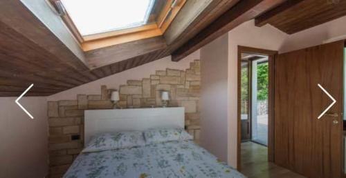 a bedroom with a large bed with a skylight at Villa Caterina in Perledo