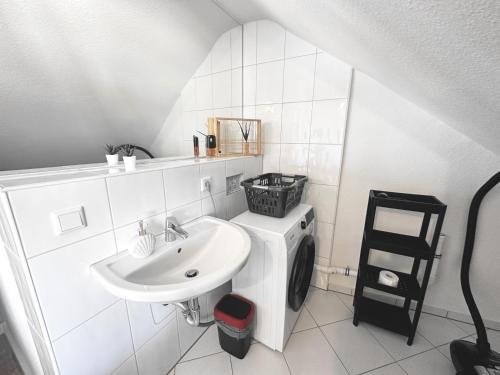 a white bathroom with a sink and a washing machine at # VAZ Apartments RS03 WLAN,TV, Küche, Parking, Autobahnähe in Remscheid