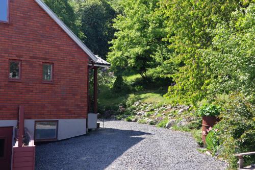 a gravel driveway next to a red brick building at Villa with mountain view in the Swedish High Coast in Docksta