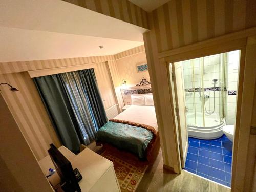 a bedroom with a bed and a bathroom with a tub at Hotel Novano in Istanbul