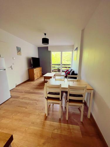 un salon avec une table et des chaises dans l'établissement Calme et arborée proche de la plage, à Cabourg