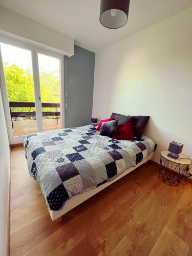 une chambre avec un lit et une grande fenêtre dans l'établissement Calme et arborée proche de la plage, à Cabourg