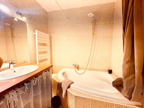 ein Badezimmer mit einer Badewanne und einem Waschbecken in der Unterkunft Le Coeur De Nîmes in Nîmes