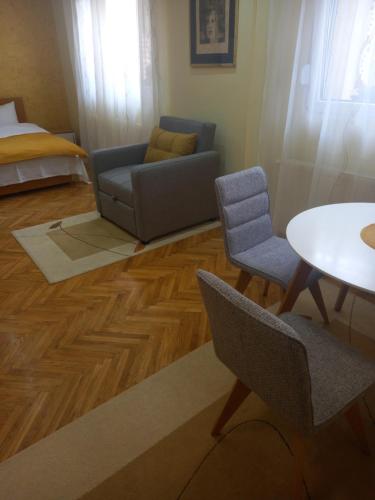 a living room with a couch and a table and chairs at LEDA Apartmani in Smederevo