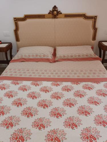 a bedroom with a bed with a floral bedspread at Il melograno in Vittorio Veneto