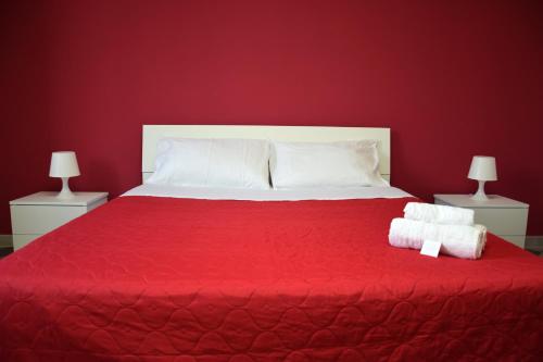 a red bedroom with a large bed with a red blanket at LYDOY APARTMENT in Reggio Calabria