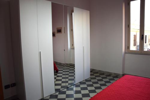 einen leeren Flur mit einem roten Teppich und einem Fenster in der Unterkunft LYDOY APARTMENT in Reggio di Calabria