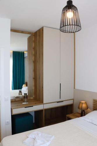 a bedroom with a white bed and a mirror at Eagles Apartments & Suites in Ulcinj
