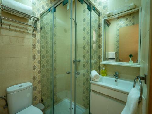 a bathroom with a shower and a toilet and a sink at ALIYA LUXURY APARTMENT El HOUDA-AGADIR in Agadir