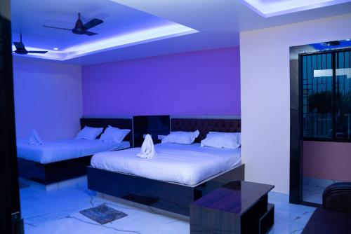 Zimmer mit 2 Betten und einem Deckenventilator in der Unterkunft Vaidehi Inn-A Unit of vaidehi guest house in Deoghar