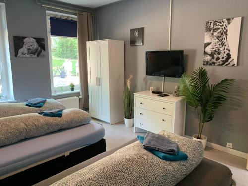 uma sala de estar com duas camas e uma televisão em Stadtnah an der Förde 51 HH em Flensburg