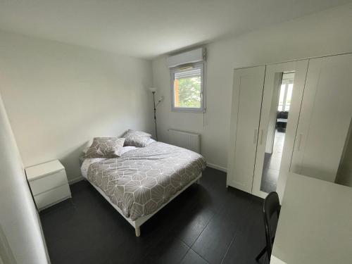 ein kleines Schlafzimmer mit einem Bett und einem Spiegel in der Unterkunft T5 4 chambres Gratte ciel, Villeurbanne, meublé in Villeurbanne