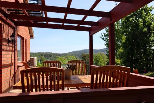 a patio with a table and chairs on a deck at Villa with mountain view in the Swedish High Coast in Docksta