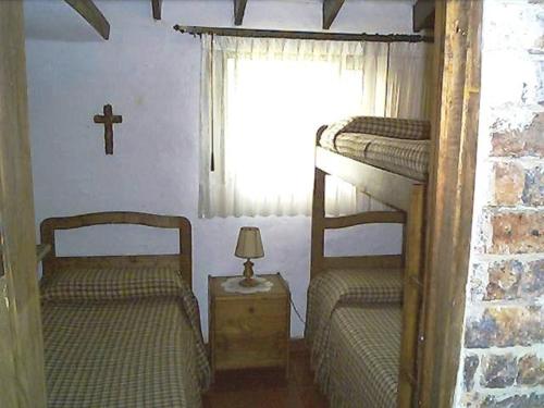 a bedroom with two bunk beds and a cross on the wall at Granja el Milagro - Cabañas Campestres in Tibasosa