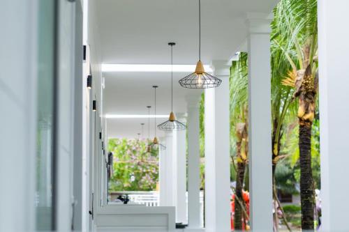 a hallway with white columns and pendant lights at NatalieLe's Homestay in Phu Quoc