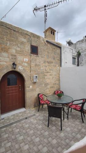 Un patio con dos sillas y una mesa y una puerta. en Heliophilia Malona, en Malona Village