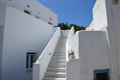 a white staircase with a potted plant on it at Cute Studio in Milos in Tripití