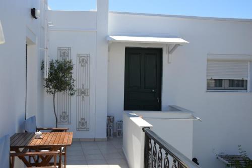 een balkon met een zwarte deur en een houten tafel bij Cute Studio in Milos in Tripití