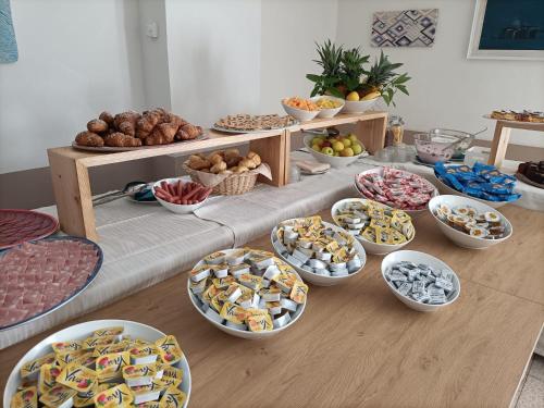 uma mesa com vários tipos diferentes de alimentos em Hotel Vianello em Lido di Jesolo