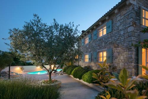 ein Gebäude mit einem Baum und einem Pool in der Unterkunft Residence Pietre d'Istria - with private service in Burići