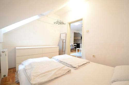 1 dormitorio blanco con 1 cama y escalera en Spacious 1-bedroom apartment, en Novi Sad
