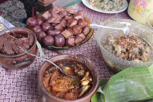 une table recouverte de différents types de nourriture dans l'établissement GRHA PAWITRA TROWULAN, à Trowulan