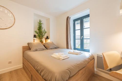 a bedroom with a bed with a clock on the wall at Le Cocon - Netflix/Wifi Fibre - Séjour Lozère in Mende