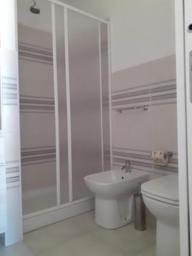 a white bathroom with a toilet and a sink at Barrumbas in Santa Lucia