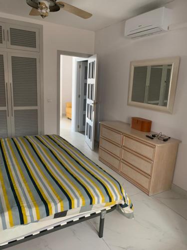 a bedroom with a bed and a dresser in it at Casa Cadi in Orihuela Costa