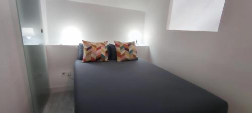a couch in a room with two pillows on it at lovecosta apartamento sur in Torremolinos