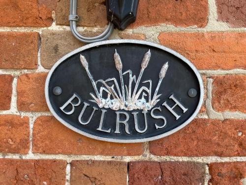 a sign on the side of a brick wall at Irelands Farm Cottages in Birmingham