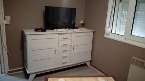- une commode blanche avec une télévision en haut dans l'établissement appartement proche de la plage, à Merlimont