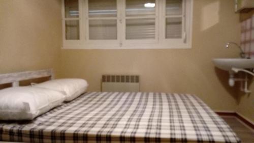 une chambre avec un lit, un lavabo et une fenêtre dans l'établissement appartement proche de la plage, à Merlimont