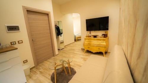 a living room with a television and a wooden floor at Sensoria Naxos Suites in Giardini Naxos