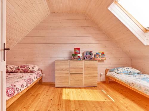 a attic bedroom with two beds and a dresser at Luxurious cottages for 7 people, 600m from the beach, Niechorze in Niechorze