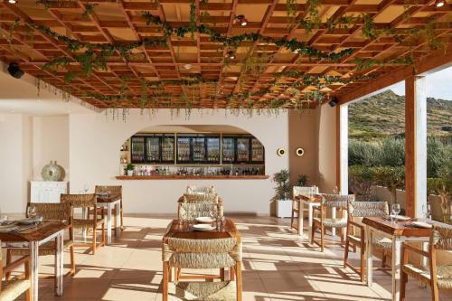 a restaurant with tables and chairs and a bar at Vasia Sea Retreat in Sissi