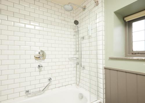 y baño con ducha de azulejos blancos y bañera. en Red Lion Hotel by Greene King Inns en Banbury