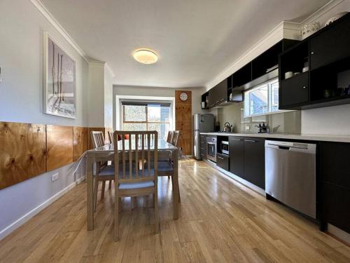 a kitchen with a table and chairs in a room at Cape Cod Chalet, alpine-getaways in Dinner Plain