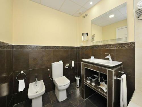 a bathroom with a toilet and a sink at Hotel Salobreña Suites in Salobreña