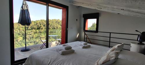 a bedroom with a white bed and a large window at Mas des Buscades in Cabris