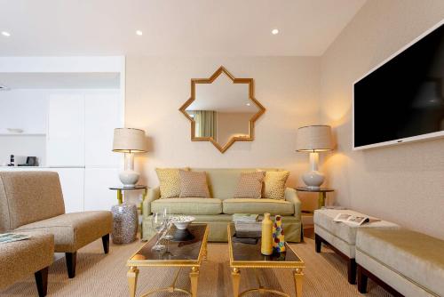 a living room with a couch and a tv at Genteel Home Betis 67 in Seville