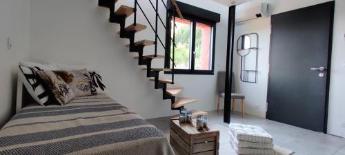 a bedroom with a bed and a spiral staircase at Mas des Buscades in Cabris